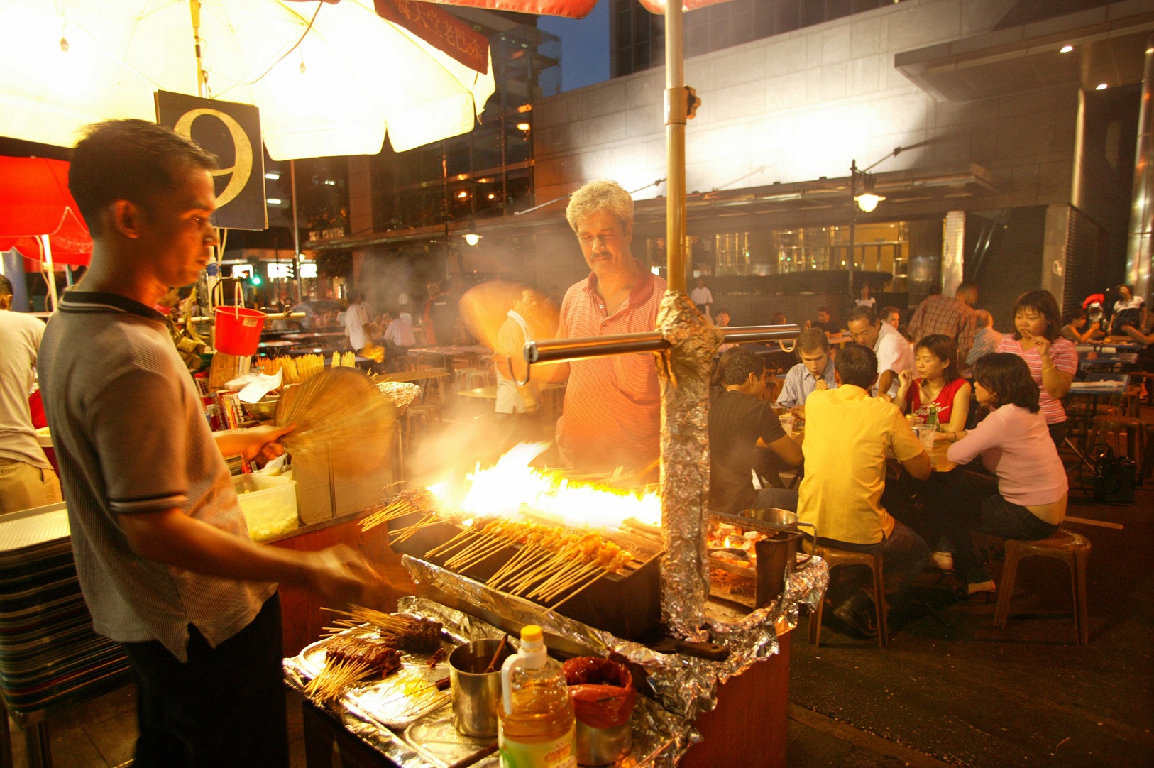 Man grilling satay outside Lau Pa Sat